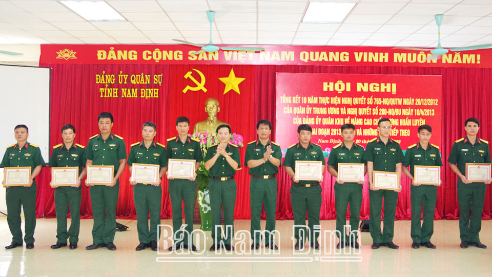 Đồng chí Đại tá Lương Văn Kiểm, Ủy viên Ban TVTU, Chỉ huy trưởng Bộ CHQS tỉnh trao thưởng cho các tập thể, cá nhân đạt thành tích xuất sắc trong thực hiện Nghị quyết 765-NQ/QUTW.