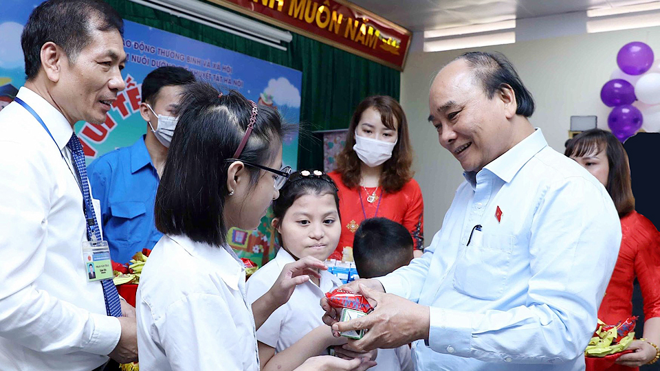 Chủ tịch nước Nguyễn Xuân Phúc tặng quà cho trẻ khuyết tật.  Ảnh: An Đăng/TTXVN