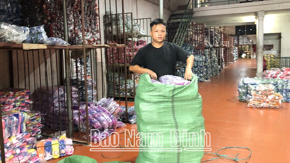 Nhân viên cơ sở giày dép Hải Yến của ông Đặng Đình Chanh, xã Mỹ Hưng (Mỹ Lộc) đóng gói sản phẩm.