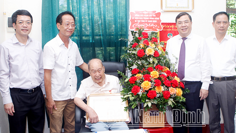 Đồng chí Bí thư Tỉnh ủy Phạm Gia Túc thăm, tặng hoa chúc mừng đảng viên Lê Xuân Thụ, sinh năm 1925, xã Nam Toàn (Nam Trực).