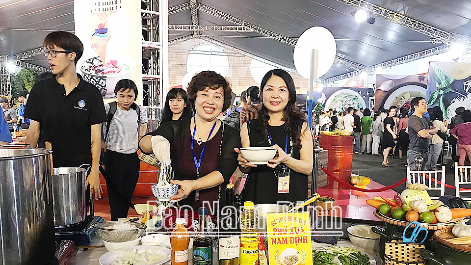 Chị Lê Thị Thiết (bên trái), Chủ tịch Hiệp hội Văn hóa ẩm thực Nam Định giới thiệu phở Nam Định với bạn bè trong nước.