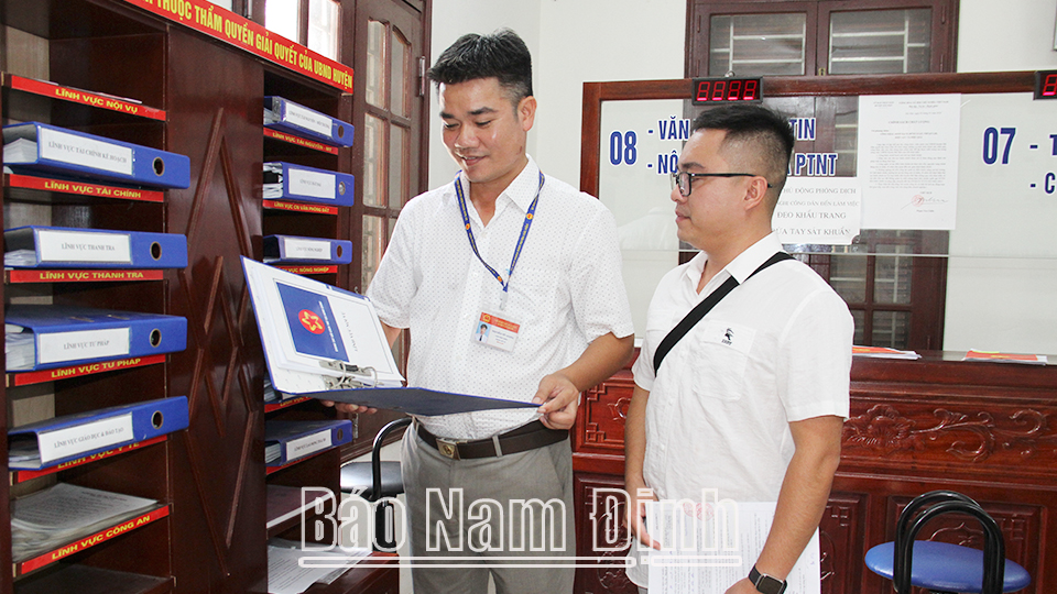Cán bộ Phòng Nội vụ huyện Hải Hậu hướng dẫn người dân làm thủ tục hành chính tại Trung tâm Giao dịch hành chính một cửa huyện.