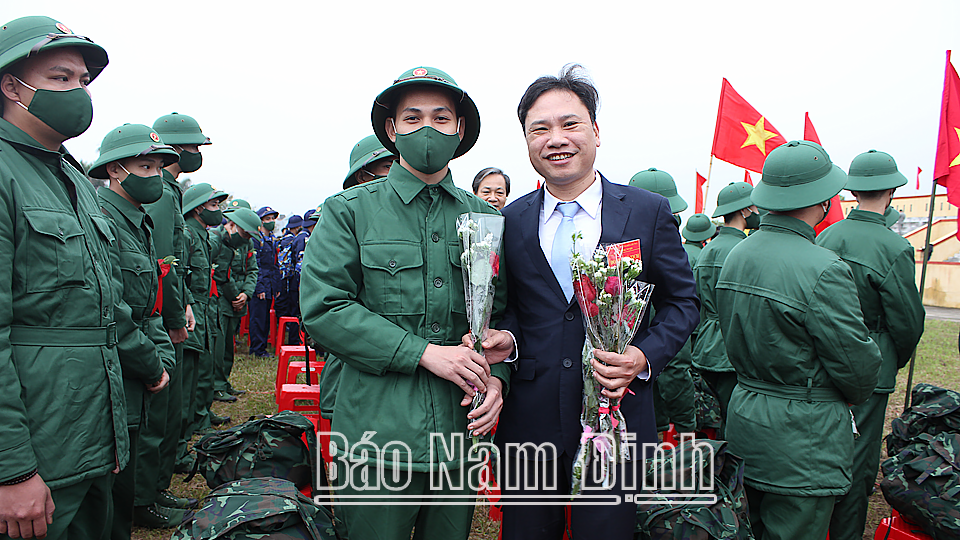 Đồng chí Mai Thanh Long, TUV, Phó Chủ tịch HĐND tỉnh tặng hoa chúc mừng các thanh niên ưu tú huyện Hải Hậu trước giờ lên đường làm nhiệm vụ bảo vệ Tổ quốc.