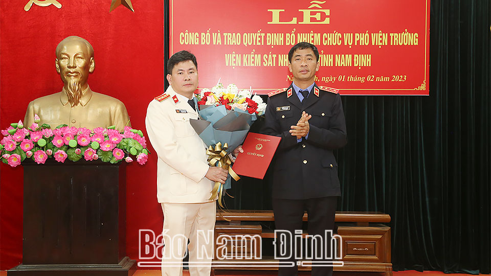 Đồng chí Nguyễn Duy Giảng, Phó Viện trưởng Viện KSND tối cao trao Quyết định và tặng hoa chúc mừng đồng chí Trần Mạnh Đông