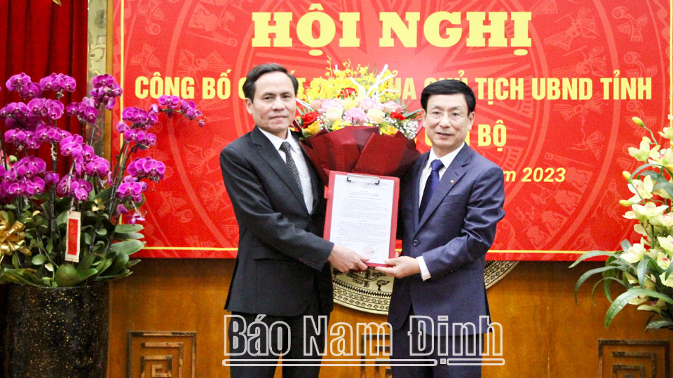 Đồng chí Phạm Đình Nghị, Phó Bí thư Tỉnh ủy, Chủ tịch UBND tỉnh trao quyết định và tặng hoa chúc mừng đồng chí Lưu Văn Dương.