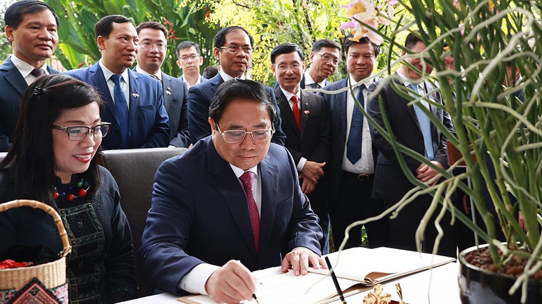Thủ tướng Phạm Minh Chính ký sổ lưu niệm khi đến dự lễ đặt tên hoa lan tại Vườn Thực vật Singapore. Ảnh: Dương Giang/TTXVN