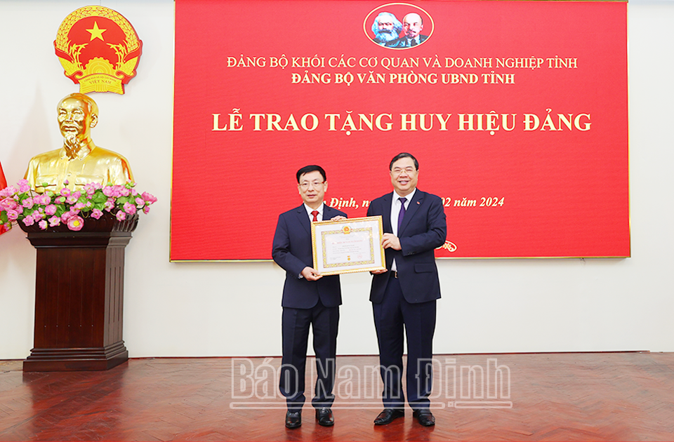 Đồng chí Bí thư Tỉnh ủy Phạm Gia Túc trao tặng Huy hiệu Đảng cho đồng chí Chủ tịch UBND tỉnh Phạm Đình Nghị. 
