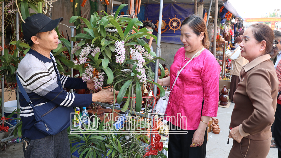 Du khách chọn mua hoa lan tại chợ Viềng xã Kim Thái (Vụ Bản). 
