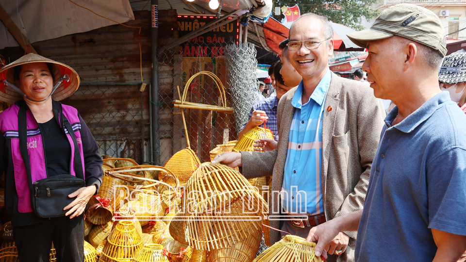 Nhiều du khách thích thú vây quanh một quầy hàng nông cụ tại chợ Viềng xã Kim Thái (Vụ Bản). 
