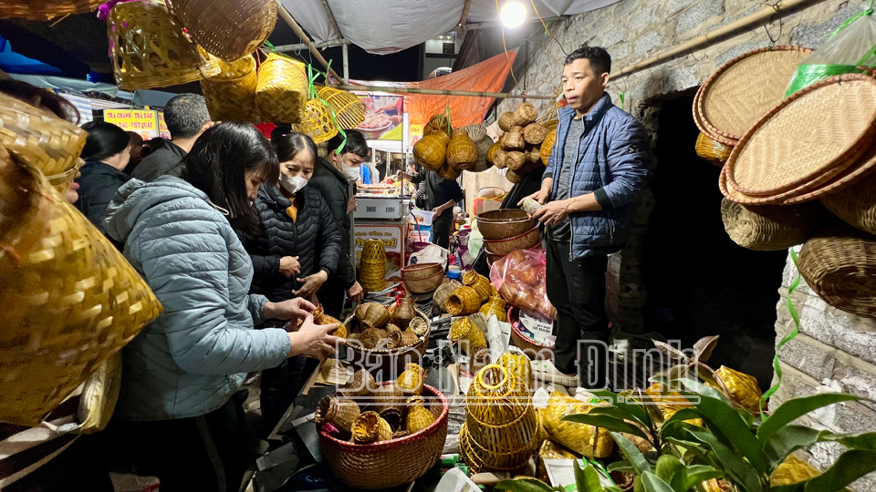 Du khách mua các sản phẩm làm từ tre nứa tại chợ Viềng Chùa. 

