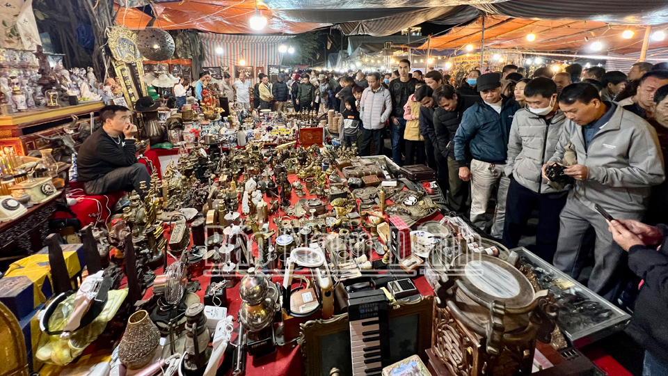 Du khách tham quan gian hàng bán đồ cổ tại chợ Viềng Chùa. 
