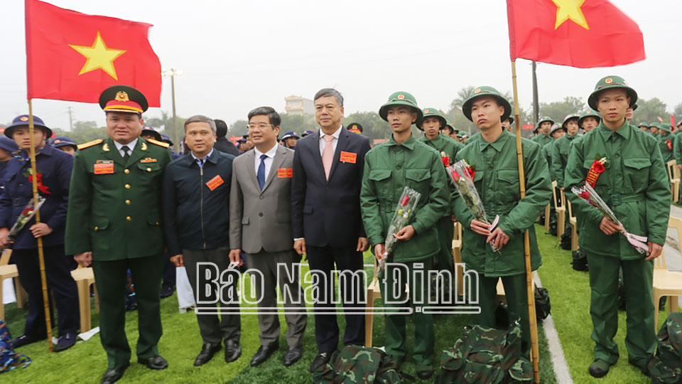 Các đồng chí Trần Lê Đoài, TUV, Phó Chủ tịch UBND tỉnh; lãnh đạo huyện Nghĩa Hưng tặng hoa động viên các tân binh huyện Nghĩa Hưng lên đường nhập ngũ.