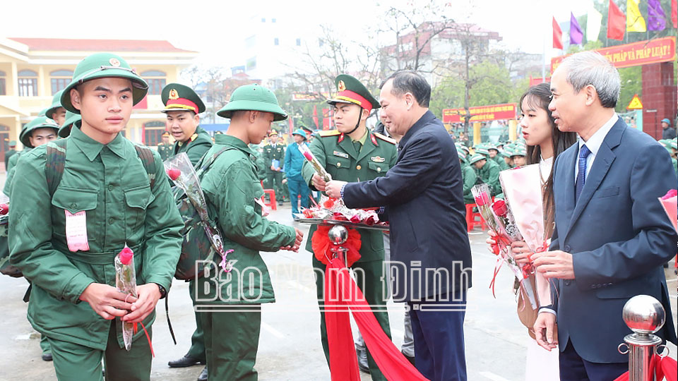 Đồng chí Phó Bí thư Thường trực Tỉnh ủy Lê Quốc Chỉnh và các đại biểu tặng hoa tân binh huyện Trực Ninh lên đường nhập ngũ.