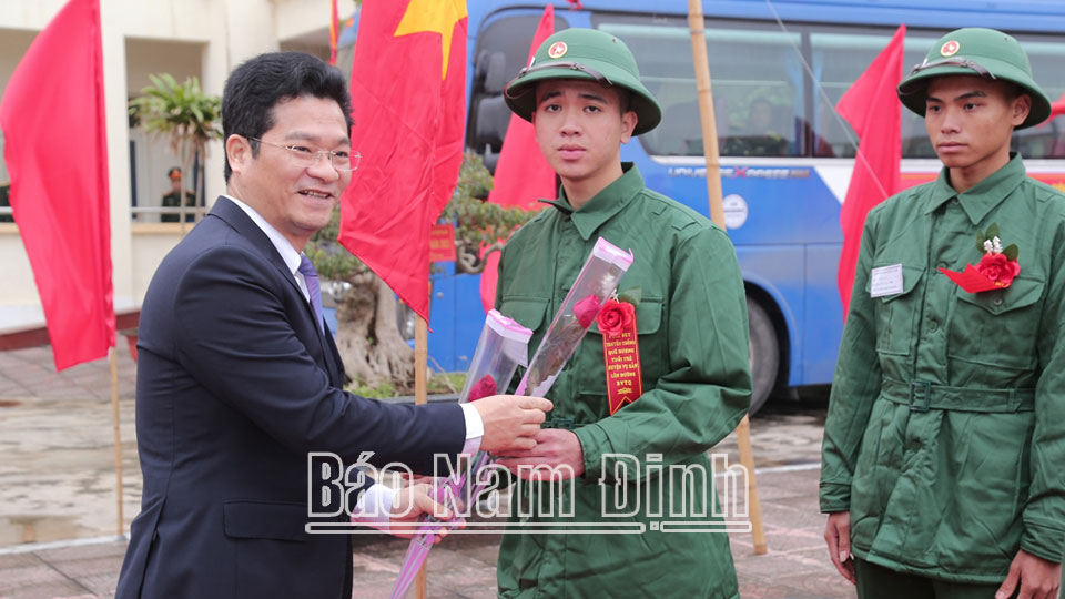 Đồng chí Trần Anh Dũng, Ủy viên Ban TVTU, Phó Chủ tịch Thường trực UBND tỉnh tặng hoa, động viên tân binh huyện Vụ Bản lên đường nhập ngũ.
