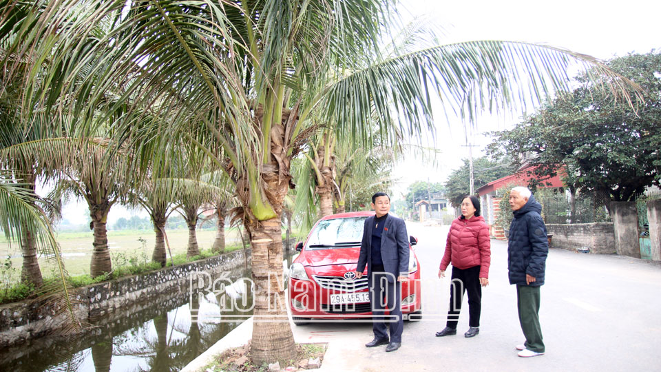 Ông Nguyễn Đăng Khoa (ngoài cùng bên trái) cùng với hội viên chi Hội Người cao tuổi thôn Bồng Quỹ, xã Yên Phong (Ý Yên) đảm nhận trồng và chăm sóc hàng dừa, tạo cảnh quan môi trường xanh - sạch - đẹp.