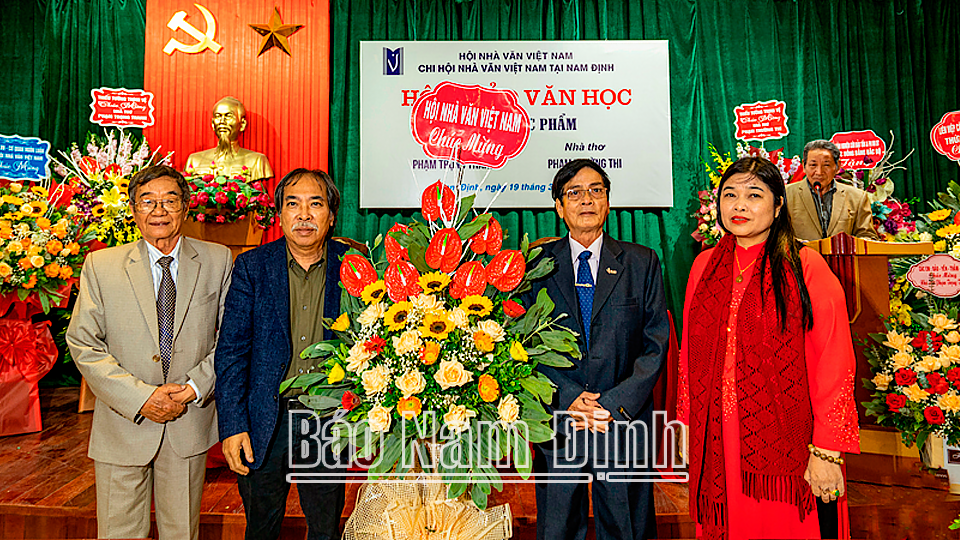 Chủ tịch Hội Nhà văn Việt Nam Nguyễn Quang Thiều tặng lẵng hoa cho hai nhà thơ Phạm Trọng Thanh và Phạm Trường Thi.