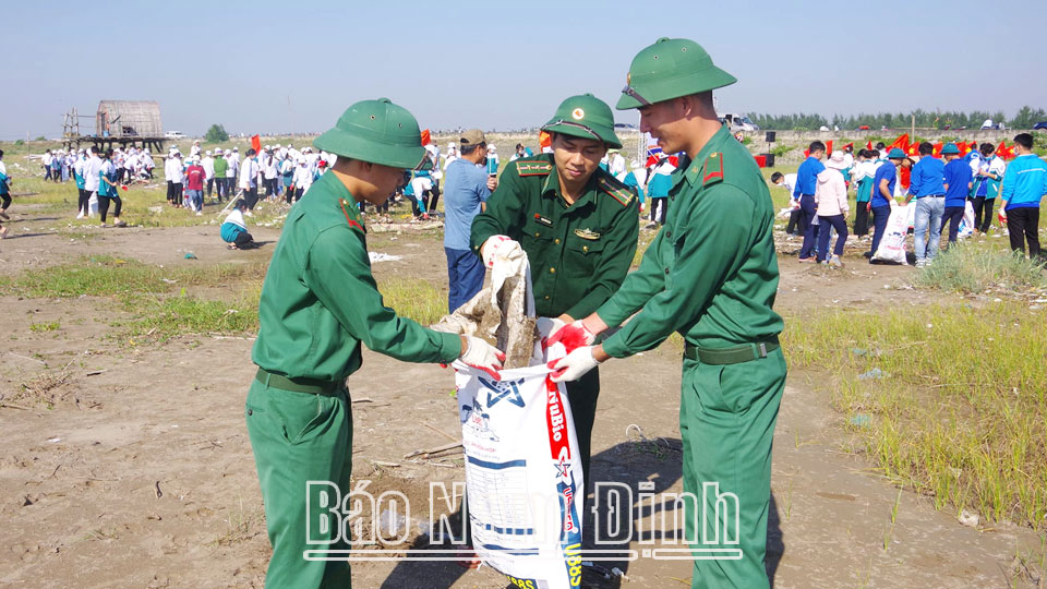 Cán bộ, chiến sĩ Bộ đội Biên phòng tỉnh tham gia thu gom rác thải, dọn vệ sinh khu vực bãi biển xã Giao Hải 
(Giao Thủy).