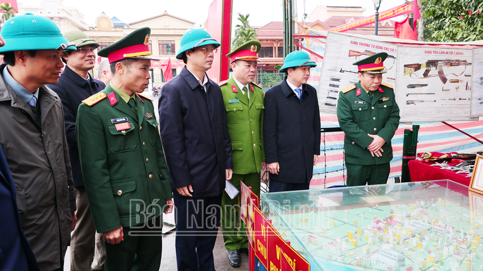 Các đồng chí lãnh đạo Bộ CHQS tỉnh, lãnh đạo thành phố Nam Định quan sát sơ đồ phòng thủ tại Lễ ra quân huấn luyện của LLVT thành phố Nam Định năm 2024. 
