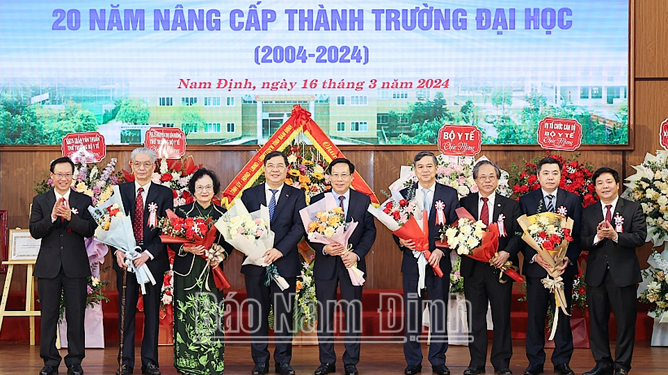 Các đồng chí lãnh đạo, nguyên lãnh đạo Bộ Y tế, tỉnh chụp ảnh lưu niệm với lãnh đạo Trường Đại học Điều dưỡng Nam Định. 
