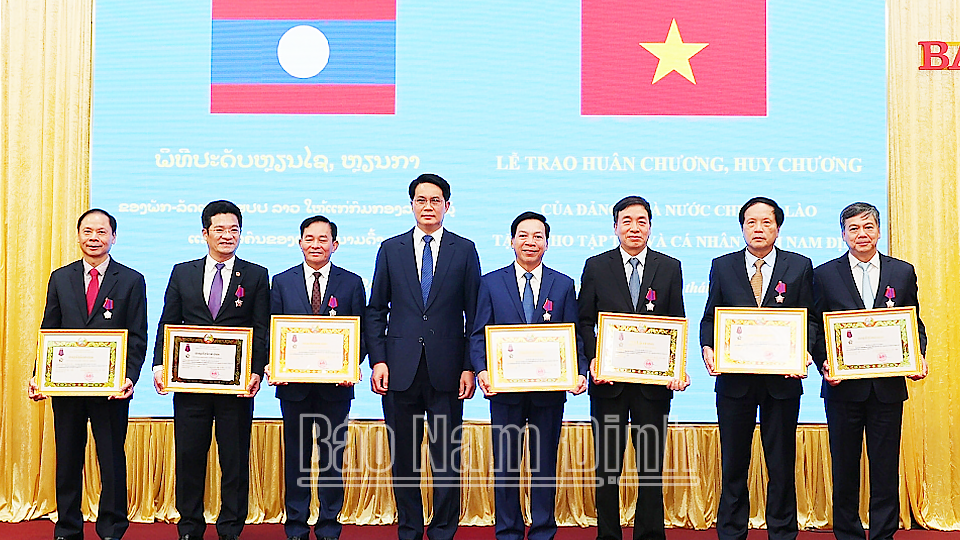 Đồng chí Bí thư Tỉnh ủy kiêm Tỉnh trưởng tỉnh U Đôm Xay trao Huân chương Tự do Hạng III cho các đồng chí lãnh đạo tỉnh. 
