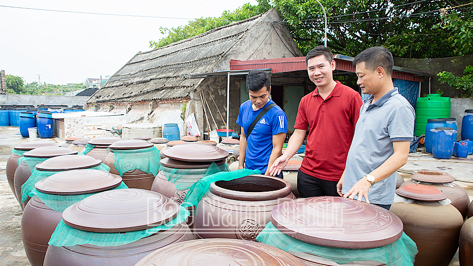 Anh Nguyễn Đức Duy (đứng giữa) giới thiệu với du khách quy trình sản xuất sản phẩm “Nước mắm Nhà thờ đổ”