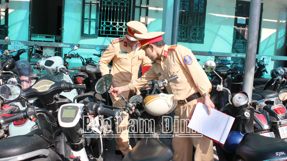 Cán bộ Phòng Cảnh sát Giao thông (Công an tỉnh) kiểm tra việc chấp hành quy định pháp luật về sử dụng xe máy, xe điện của học sinh tại Trường THPT Ngô Quyền (TP Nam Định).