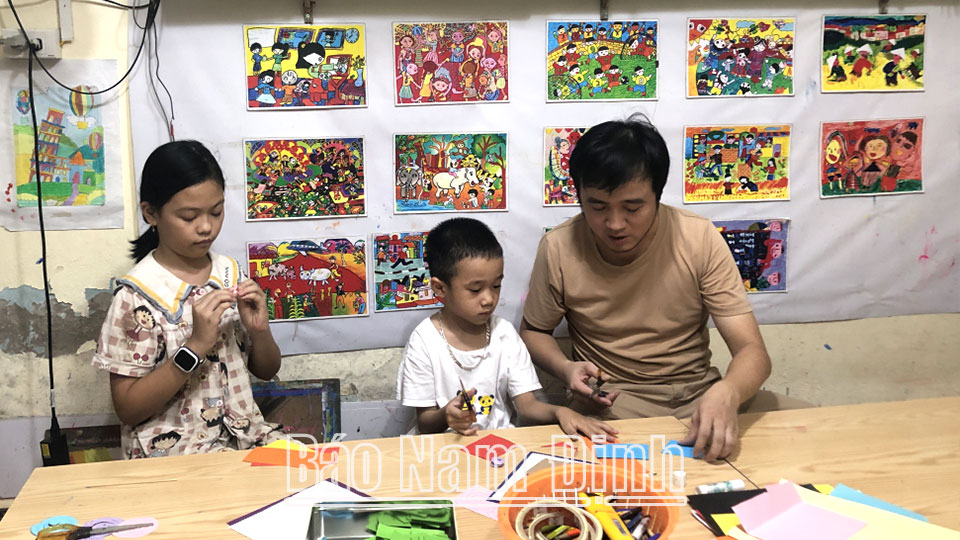 Anh Trần Văn Hậu, chủ của xưởng mỹ thuật sáng tạo Hậu Trần art Nam Định (TP Nam Định) hướng dẫn học sinh cắt giấy tạo hình.