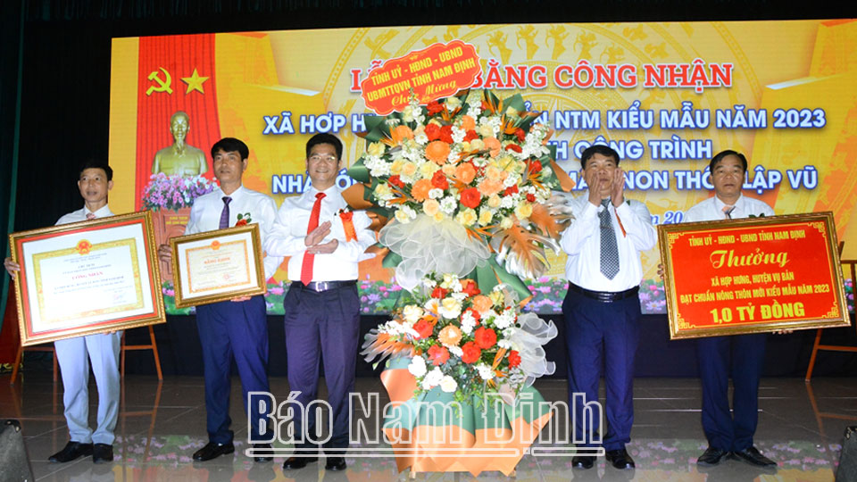 Đồng chí Trần Anh Dũng, Uỷ viên Ban TVTU, Phó Chủ tịch Thường trực UBND tỉnh tặng hoa chúc mừng Đảng bộ, chính quyền và Nhân dân xã Hợp Hưng. 