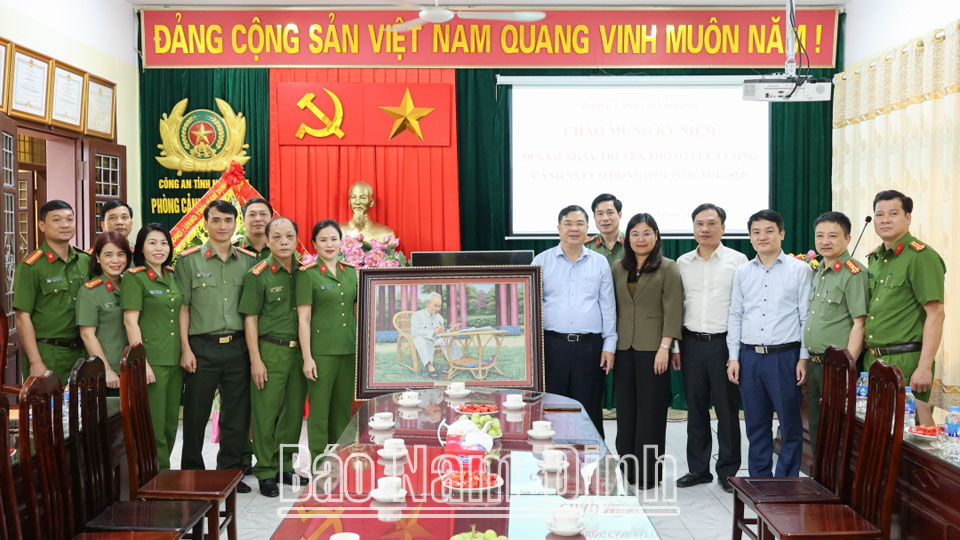 Đồng chí Phạm Gia Túc, Ủy viên BCH Trung ương Đảng, Bí thư Tỉnh ủy và các đồng chí lãnh đạo tỉnh tặng  Phòng Cảnh sát Cơ động bức tranh Bác Hồ ngồi làm việc.