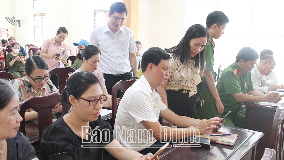 Cán bộ phường Trần Quang Khải hướng dẫn người dân cài đặt, sử dụng ứng dụng định danh điện tử VNeID.