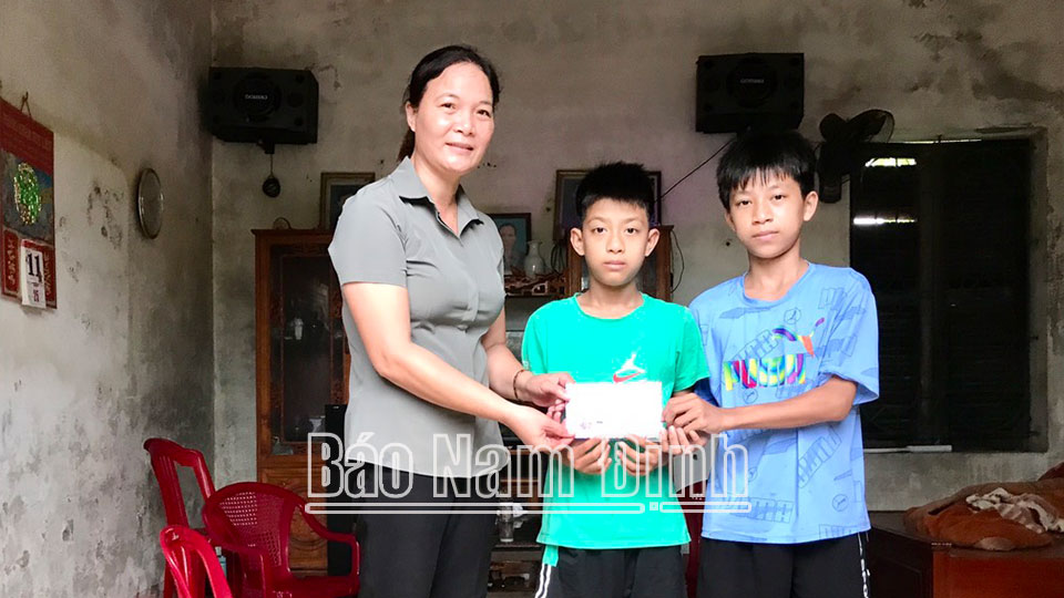 Cán bộ Hội Phụ nữ xã Hải Trung trao quà cho các con được đỡ đầu. 