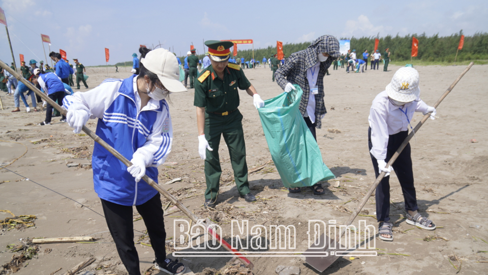Đoàn viên, thanh niên, học sinh và cán bộ, chiến sĩ Bộ CHQS tỉnh làm sạch biển tại Khu du lịch thị trấn Thịnh Long (Hải Hậu).
