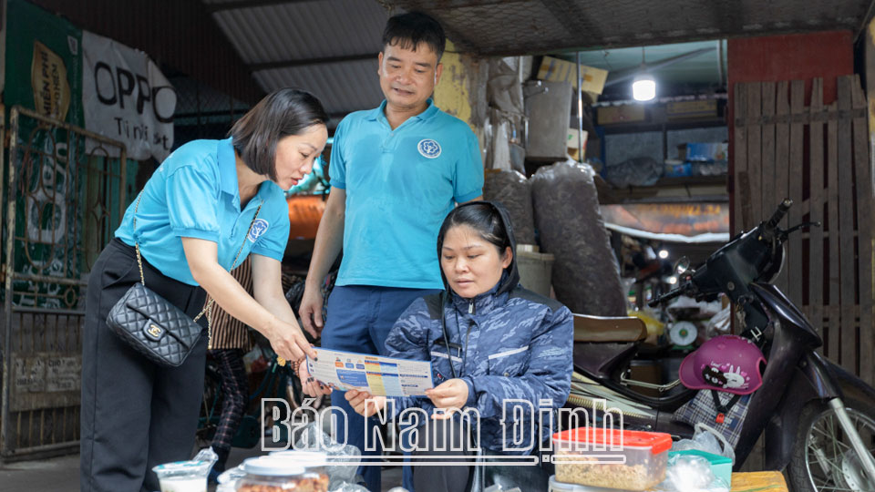Cán bộ Bảo hiểm xã hội tỉnh tuyên truyền bảo hiểm xã hội tự nguyện, bảo hiểm y tế gia đình cho người dân trên địa bàn thành phố Nam Định.