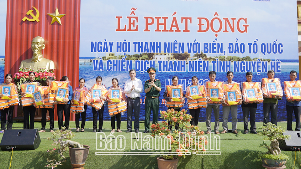 Đồng chí Trần Lê Đoài, TUV, Phó Chủ tịch UBND tỉnh và các đại biểu trao tặng 30 áo phao, cờ Tổ quốc, ảnh Bác Hồ cho ngư dân tiêu biểu huyện Hải Hậu. 
