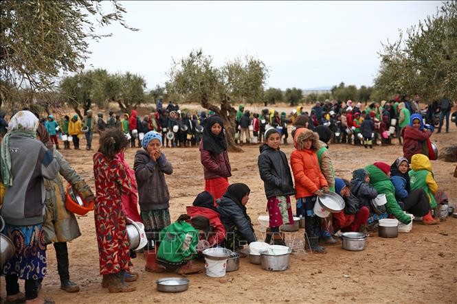 Trẻ em xếp hàng chờ nhận thức ăn cứu trợ tại trại tị nạn ở Aleppo, Syria. (Ảnh tư liệu: AFP/TTXVN)
