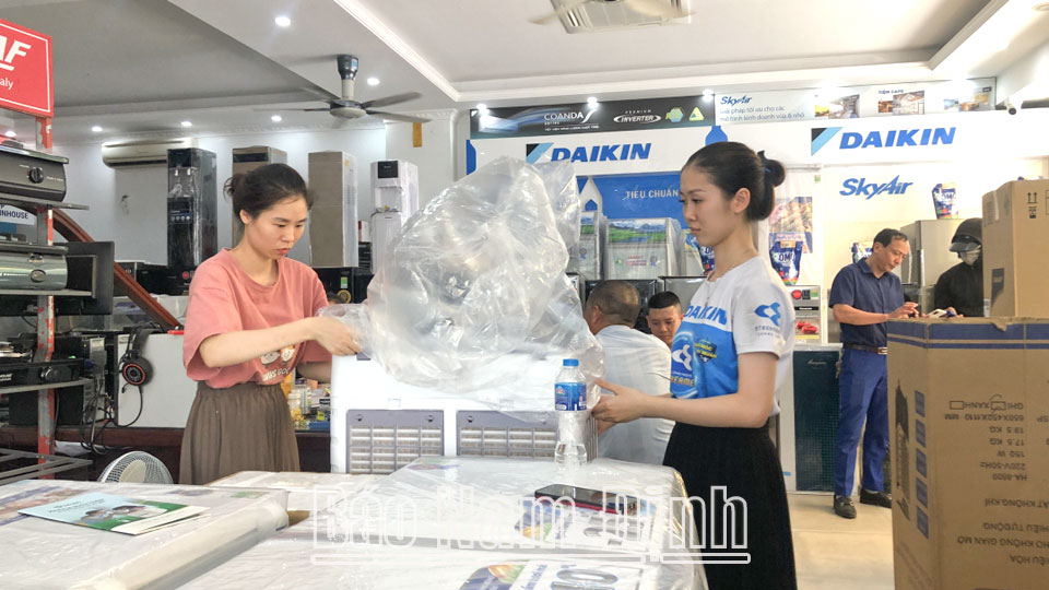 Nhân viên cửa hàng điện máy Minh Tâm (thành phố Nam Định) kiểm tra quạt điều hòa trước khi giao cho khách.