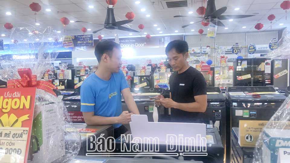 Nhân viên siêu thị Điện máy XANH (thành phố Nam Định) tư vấn hàng cho khách hàng.