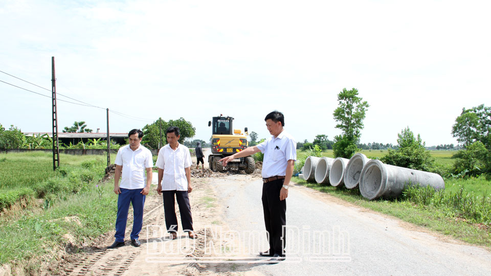 Cán bộ xã Mỹ Thịnh kiểm tra việc thi công đường giao thông nông thôn xây dựng nông thôn mới kiểu mẫu.