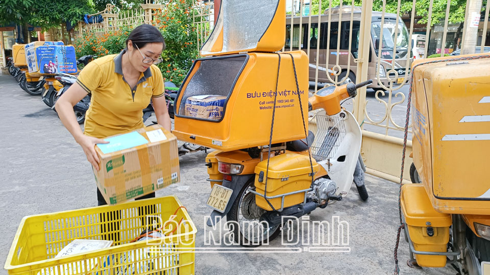Chị Trần Thị Cài, nhân viên bưu tá Bưu cục phát - Trung tâm khai thác vận chuyển (Bưu điện tỉnh) chuẩn bị bưu phẩm vận chuyển đến tận tay khách hàng.