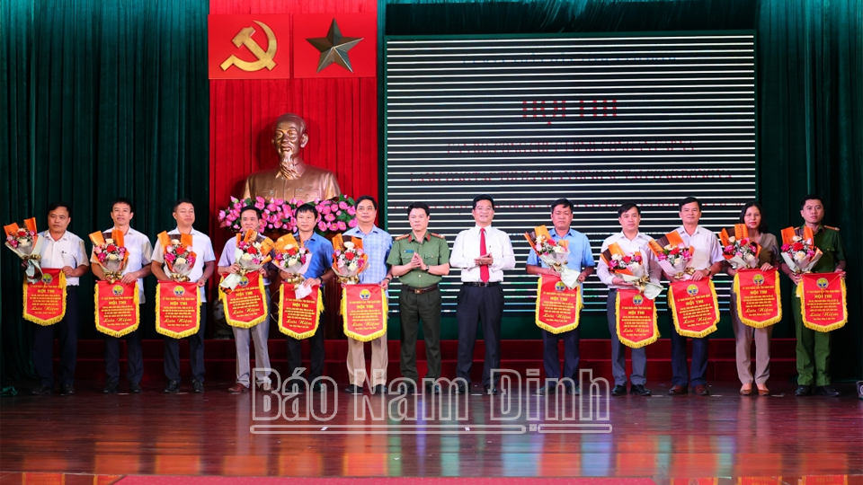 Các đồng chí Phó Chủ tịch Thường trực UBND tỉnh Trần Anh Dũng và Đại tá, Giám đốc Công an tỉnh Nguyễn Hữu Mạnh trao Cờ lưu niệm cho các đội thi. 
