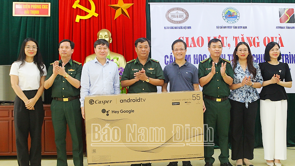 Đại diện lãnh đạo Vụ Chính sách tiền tệ (Ngân hàng Nhà nước Việt Nam) trao tặng quà cho đại diện cán bộ, chiến sĩ Đồn Biên phòng Cửa khẩu cảng Hải Thịnh. 
