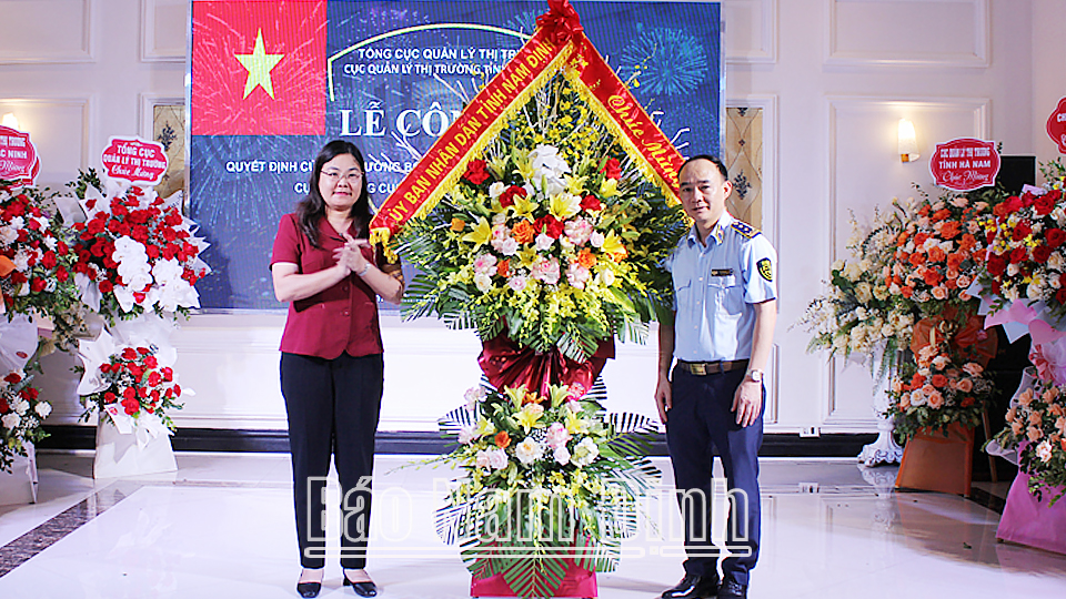Đồng chí Hà Lan Anh, TUV, Phó Chủ tịch UBND tỉnh tặng hoa chúc mừng tân Cục trưởng Cục quản lý thị trường Nam Định Lê Quang Tú.