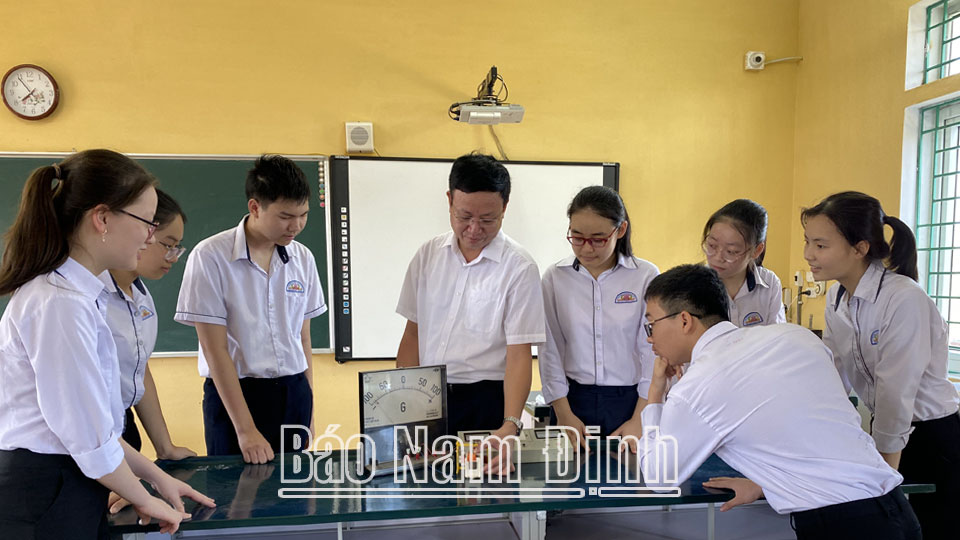Thầy Nguyễn Sỹ Hiệp, Hiệu trưởng Trường THCS Đào Sư Tích, hướng dẫn học sinh thực hành trong một giờ học Vật lý.