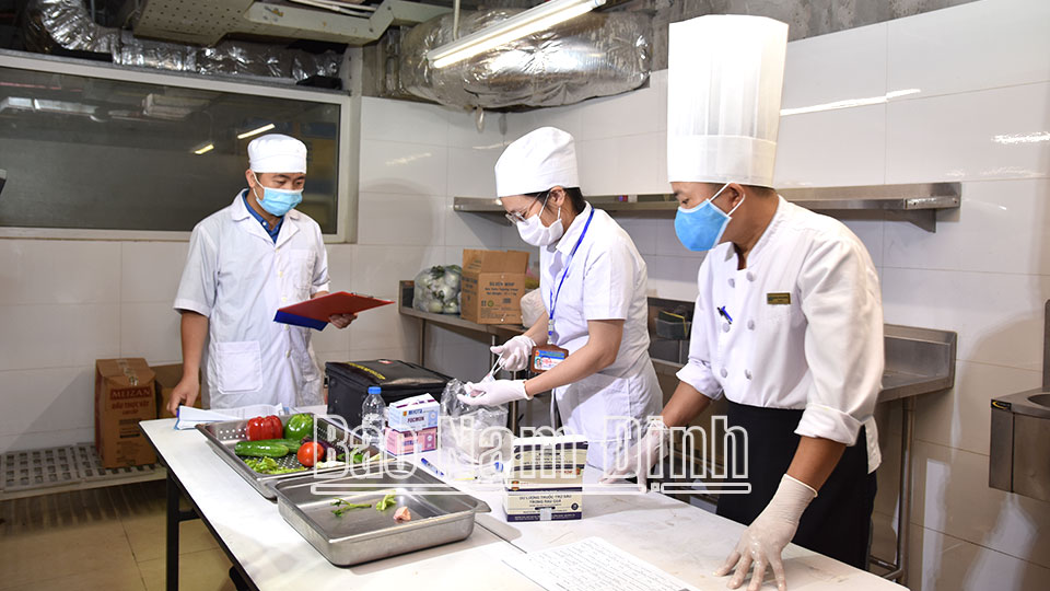 Cán bộ Chi cục An toàn vệ sinh thực phẩm tỉnh lấy mẫu xét nghiệm nhanh thực phẩm đầu vào tại bếp ăn Khách sạn Nam Cường (thành phố Nam Định).