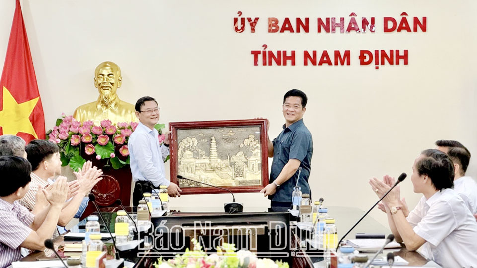 Đồng chí Trần Anh Dũng, Uỷ viên Ban TVTU, Phó Chủ tịch Thường trực UBND tỉnh tặng quà lưu niệm Đoàn công tác của tỉnh Bình Định.