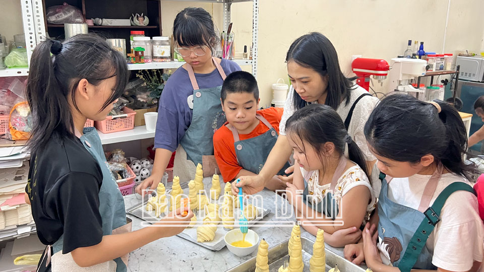 Các bạn từ 9-15 tuổi làm bánh dưới sự hướng dẫn của chị Lữ Phong, đường Giải Phóng (thành phố Nam Định).