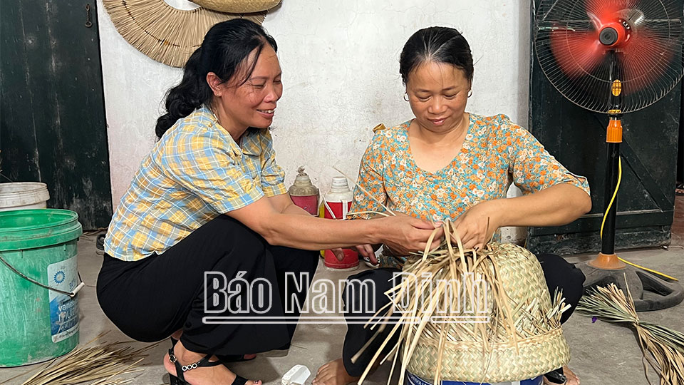 Chị Hoàng Thị Oanh, xóm 3, xã Xuân Phương (Xuân Trường) hướng dẫn thợ trong xưởng cách đan các mẫu sản phẩm mới.