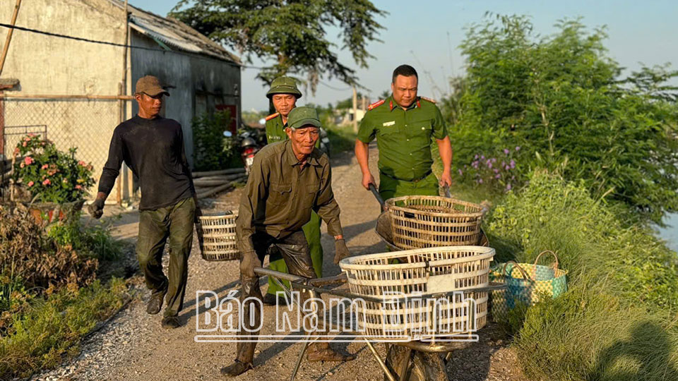 Lực lượng Công an và lực lượng tham gia bảo vệ an ninh trật tự ở cơ sở hỗ trợ người dân khu vực Cồn Xanh, huyện Nghĩa Hưng dọn dẹp mặt bằng để thi công các dự án của Tập đoàn Xuân Thiện.