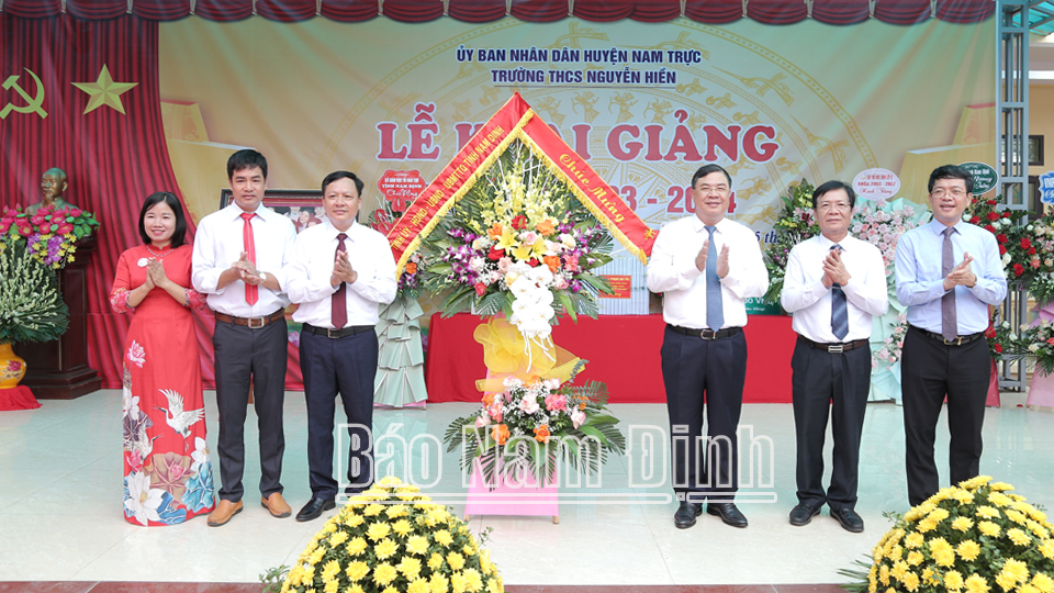 Đồng chí Bí thư Tỉnh ủy Phạm Gia Túc và lãnh đạo Sở GD - ĐT, huyện Nam Trực tặng hoa chúc mừng Trường THCS Nguyễn Hiền.