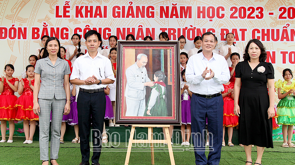 Đồng chí Phó Bí thư Thường trực Tỉnh ủy Lê Quốc Chỉnh trao tặng bức tranh “Bác Hồ đeo khăn quàng cho cháu thiếu nhi” cho trường THCS Trực Nội (Trực Ninh).